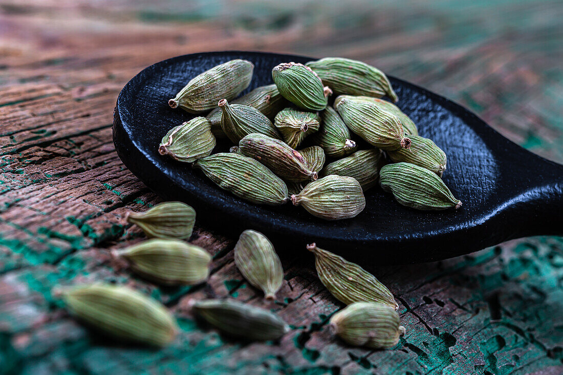 Cardamom seeds on a wooden spoon