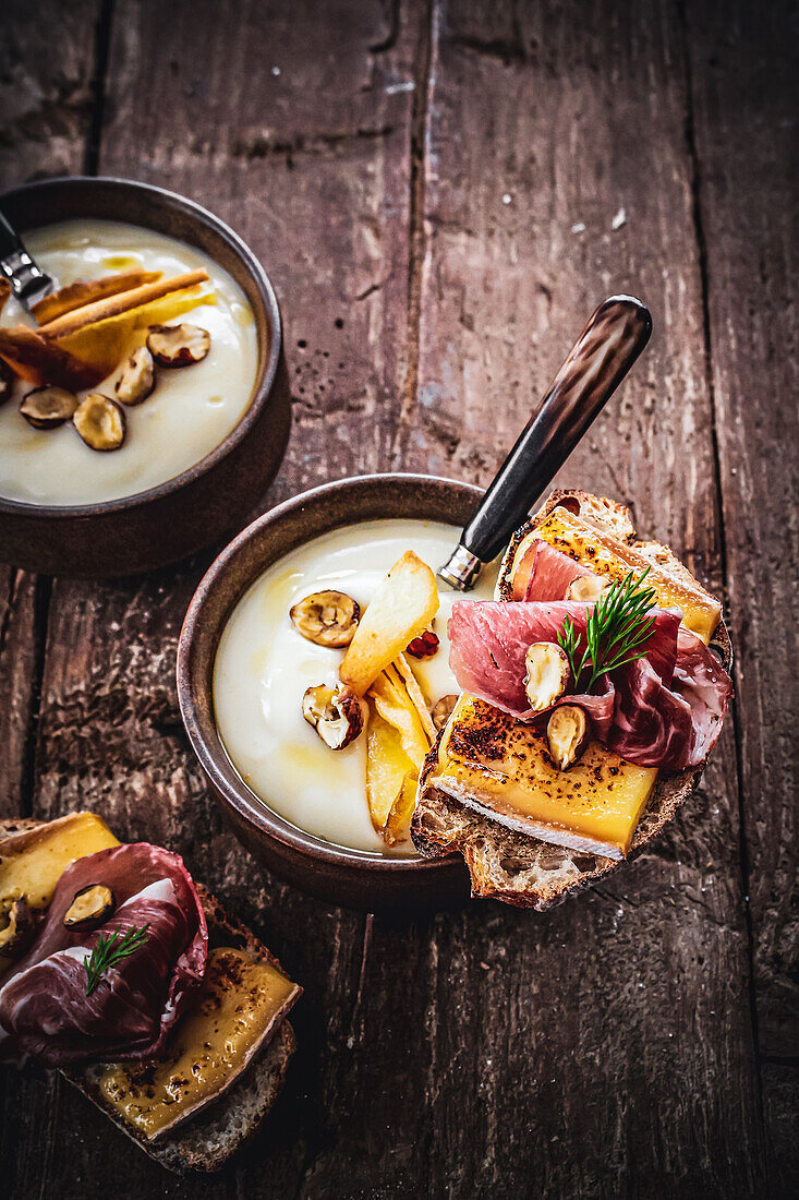 Parsnip soup served with tartine with cheese and ham