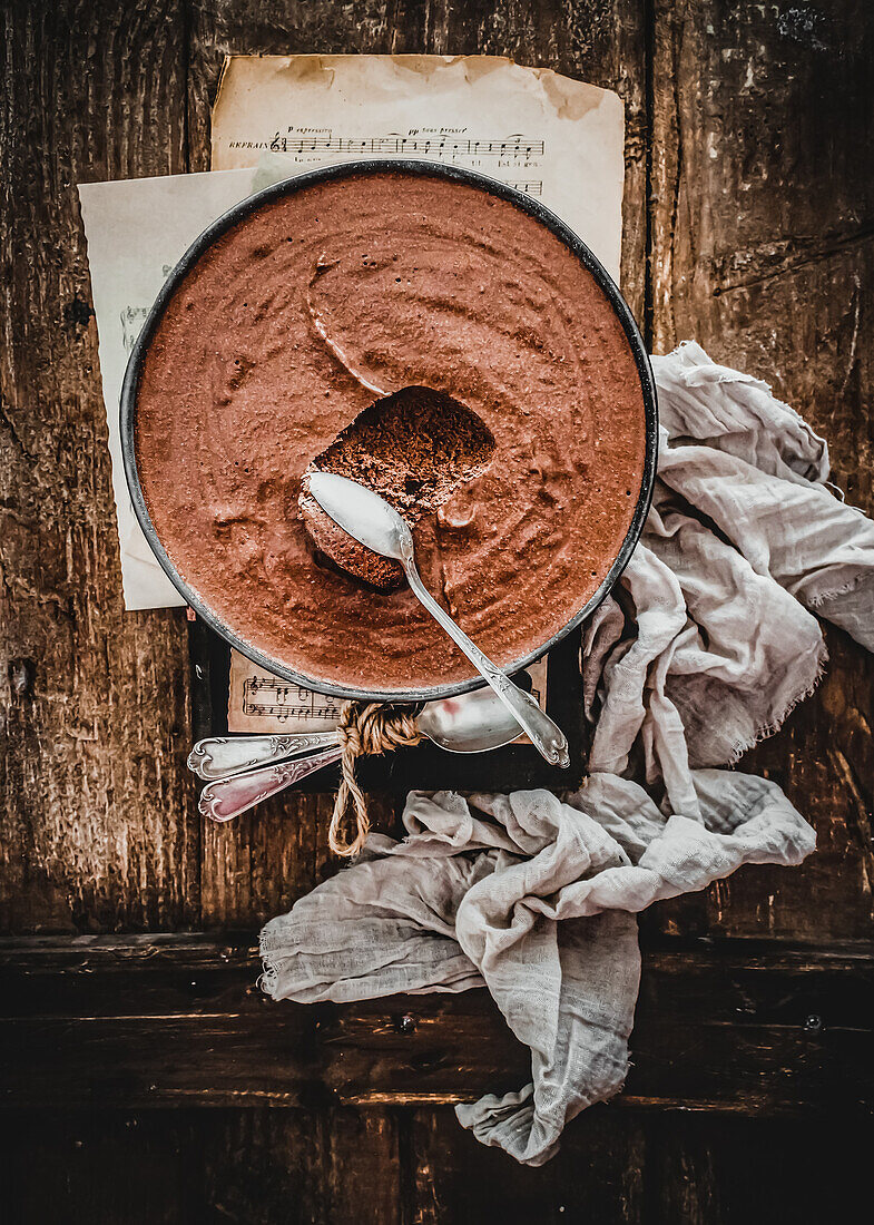Chocolate mousse in bowl on rustic wooden table