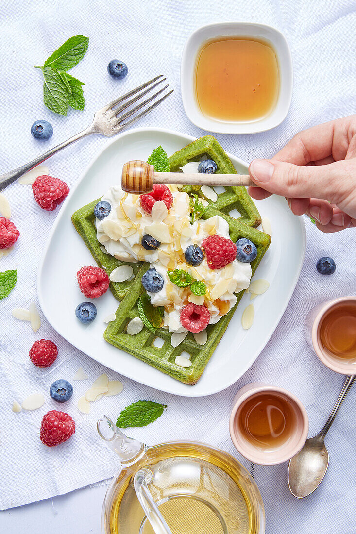Pistachio waffles with cream, honey and berries