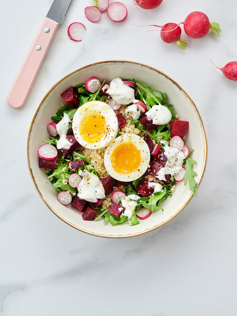 Buddha bowl with bulgur, beetroot, radishes, rocket and soft-boiled egg