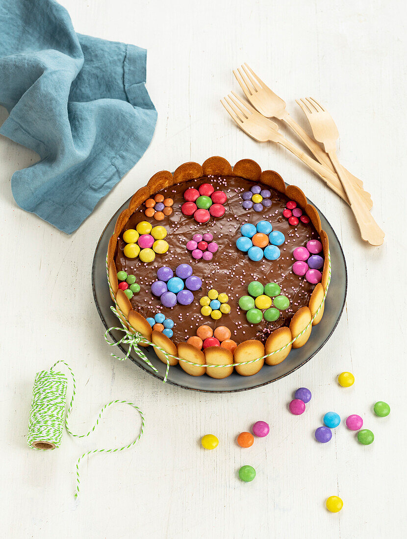 Schokoladenkuchen verziert mit Blüten aus bunten Schokolinsen