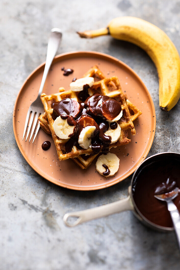 Waffles with sliced banana and melted chocolate