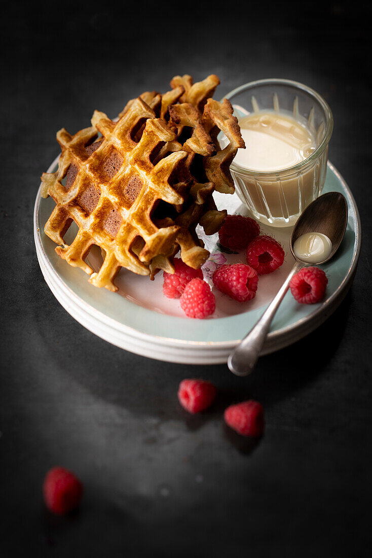 Waffles with sweet concentrated milk and raspberries