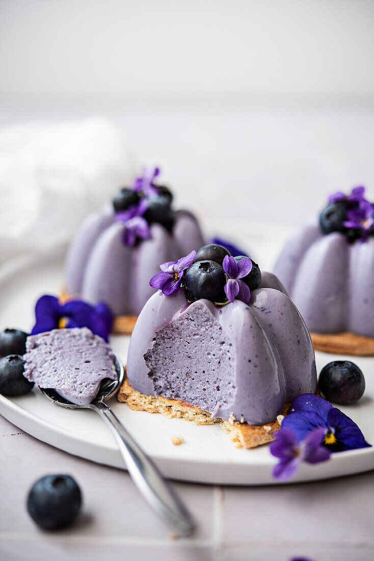Vegan purple panna cotta with blueberries and violets