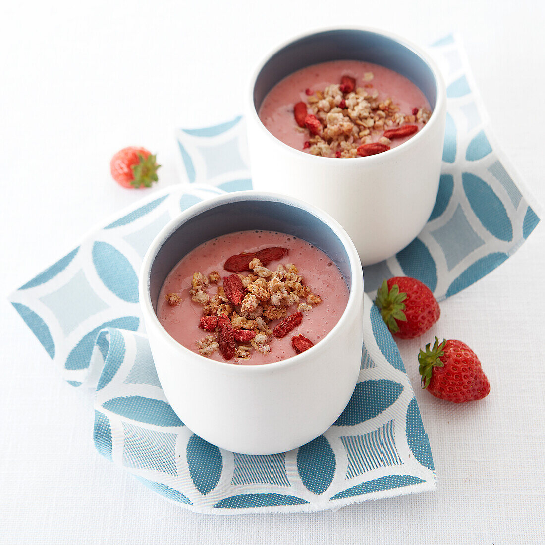 Strawberry morning smoothie garnished with puff pastry and goji beans