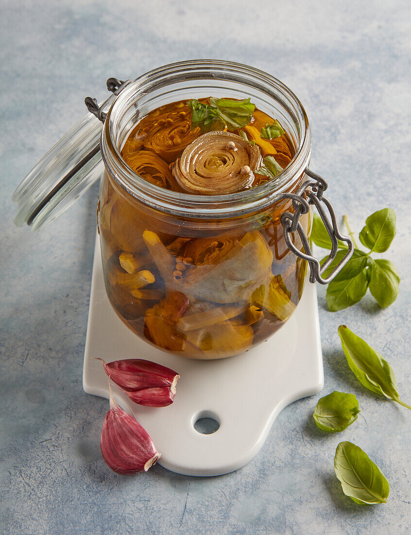 Pickled artichokes in a jar with garlic and chilli peppers