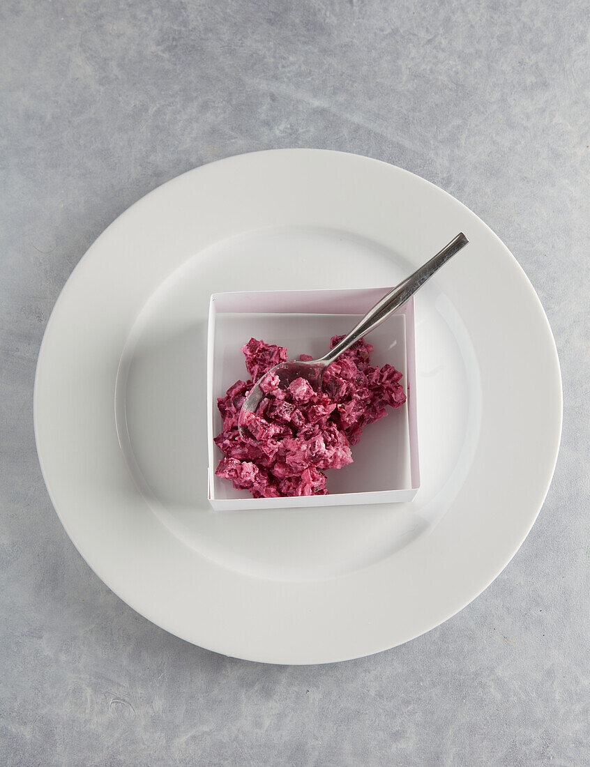 Placing the thinly chopped beetroot and red onions in the square casing