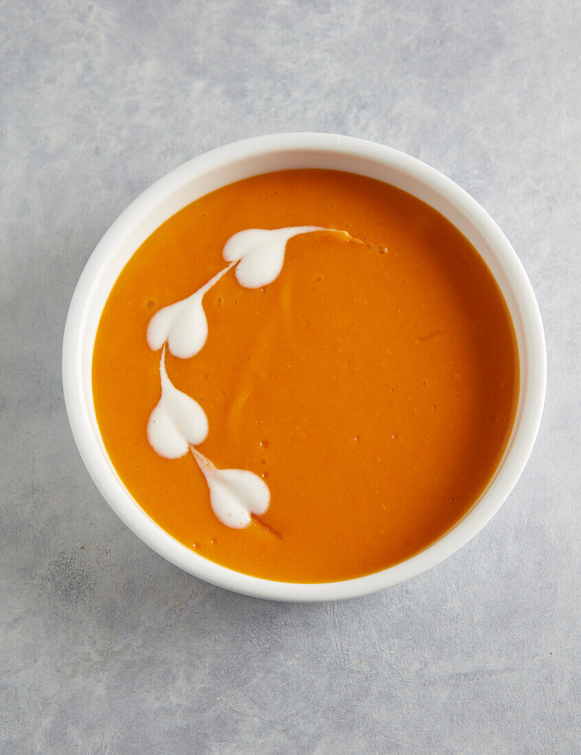 Pumpkin soup decorated with cream hearts