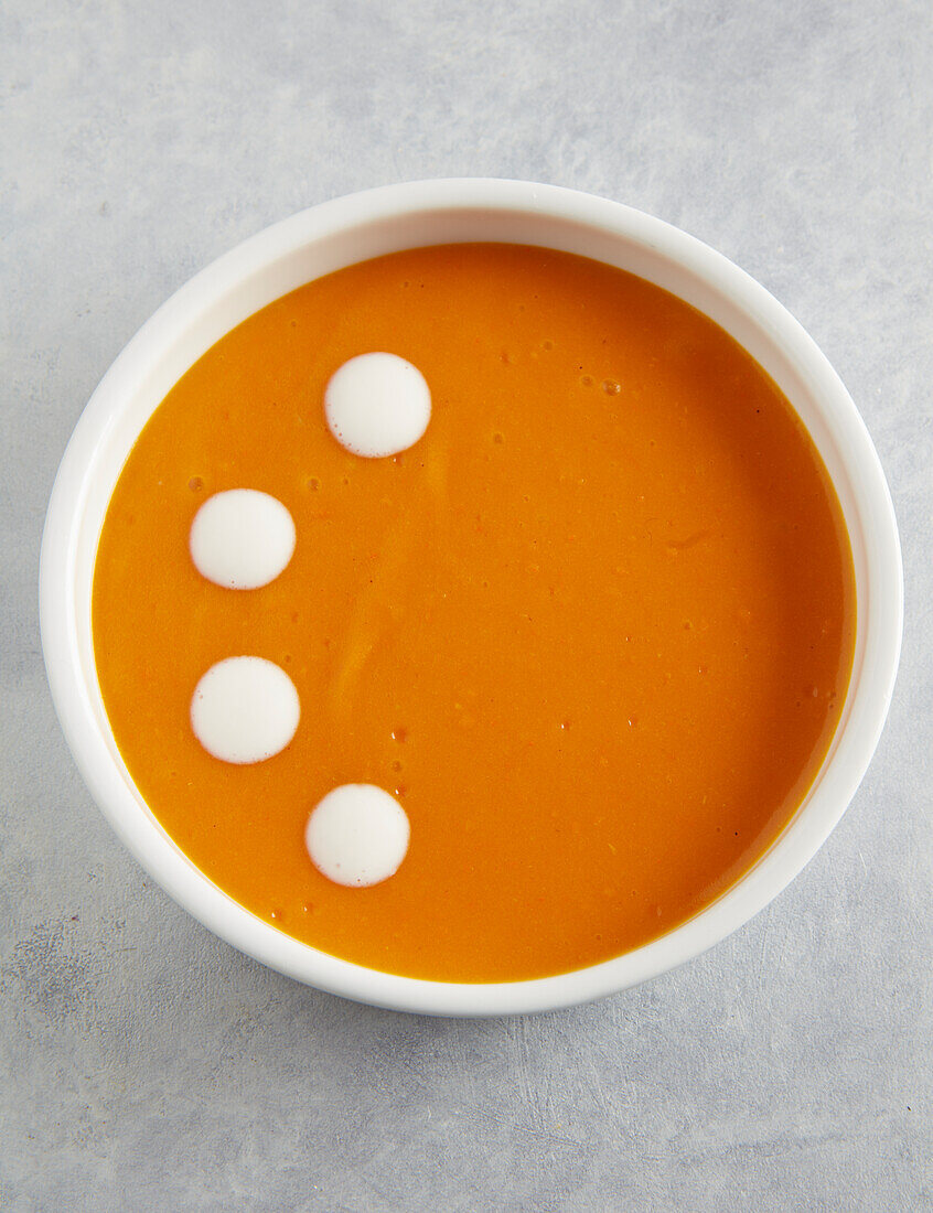 Pumpkin soup decorated with cream dots