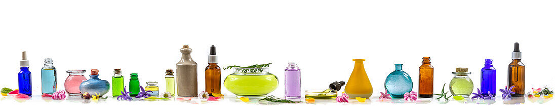Various essential oils in bottles, lined up against a white background