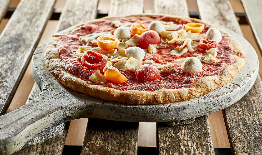 Frozen pizza with cherry tomatoes and mini mozzarella