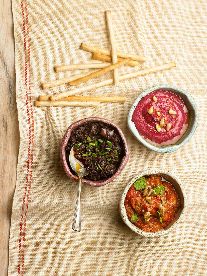 Drei Dips: Olivenpaste, Rote-Bete-Hummus, Walnussdip mit rotem Pfeffer