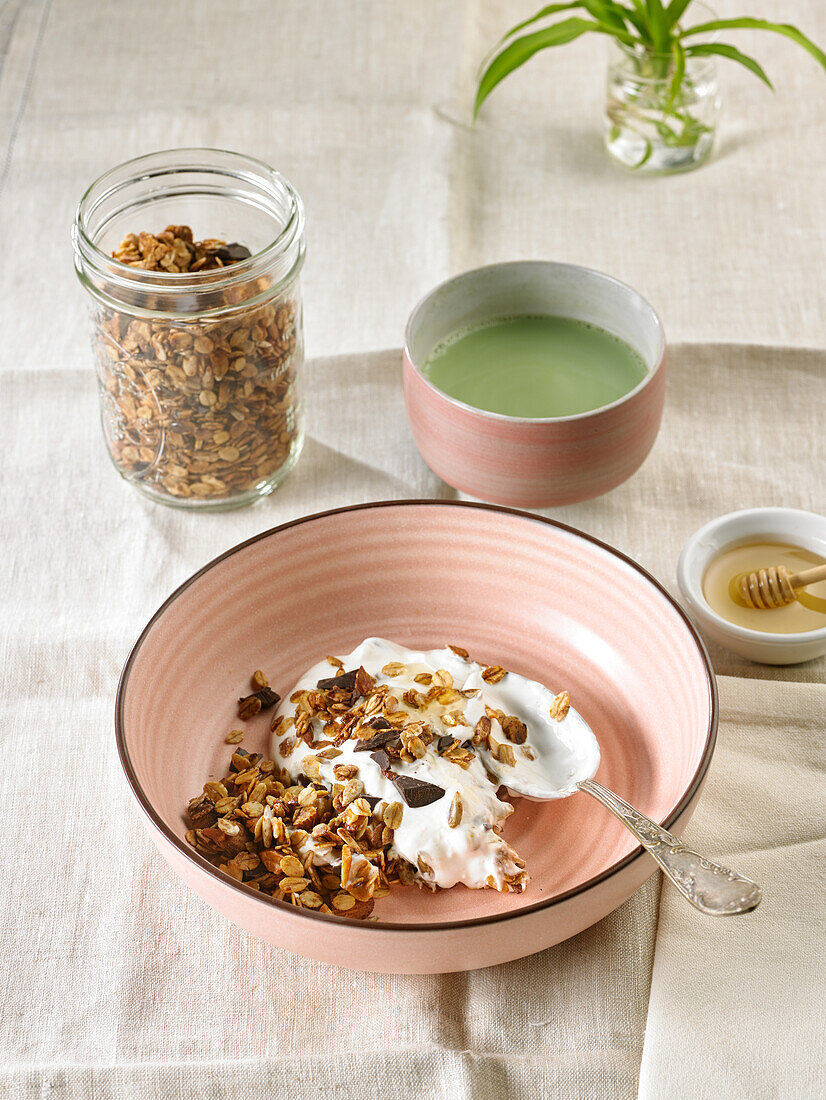 Müsli mit Trockenfrüchten, Schokolade und Quark dazu eine Tasse grünen Tee