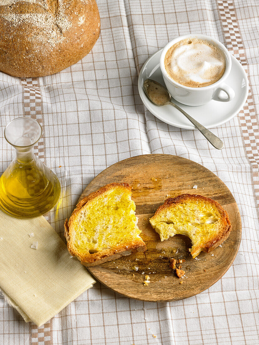 Mediterranes Frühstück mit Kaffee und Brot mit Olivenöl