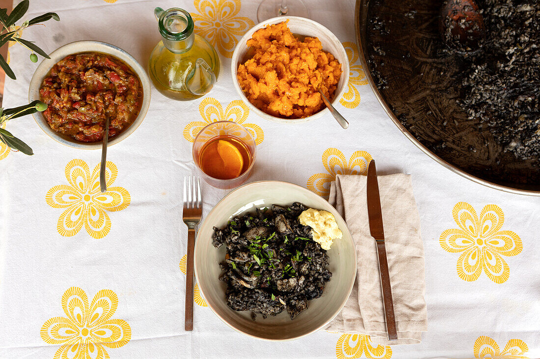 Various side dishes: black rice with aioli, carrot puree, and pepper and tomato puree