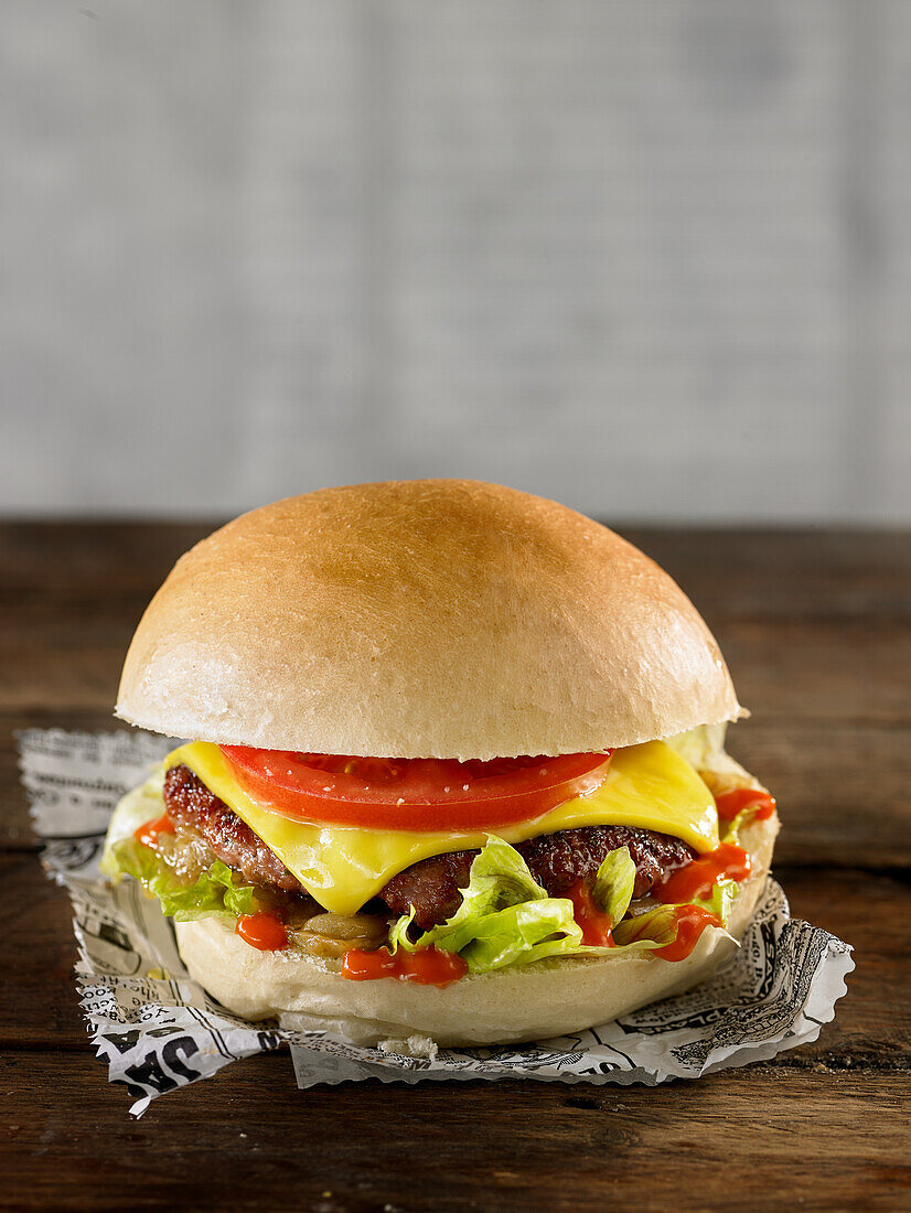 Chicken burger with tomatoes, cheddar, pickles, salad and ketchup