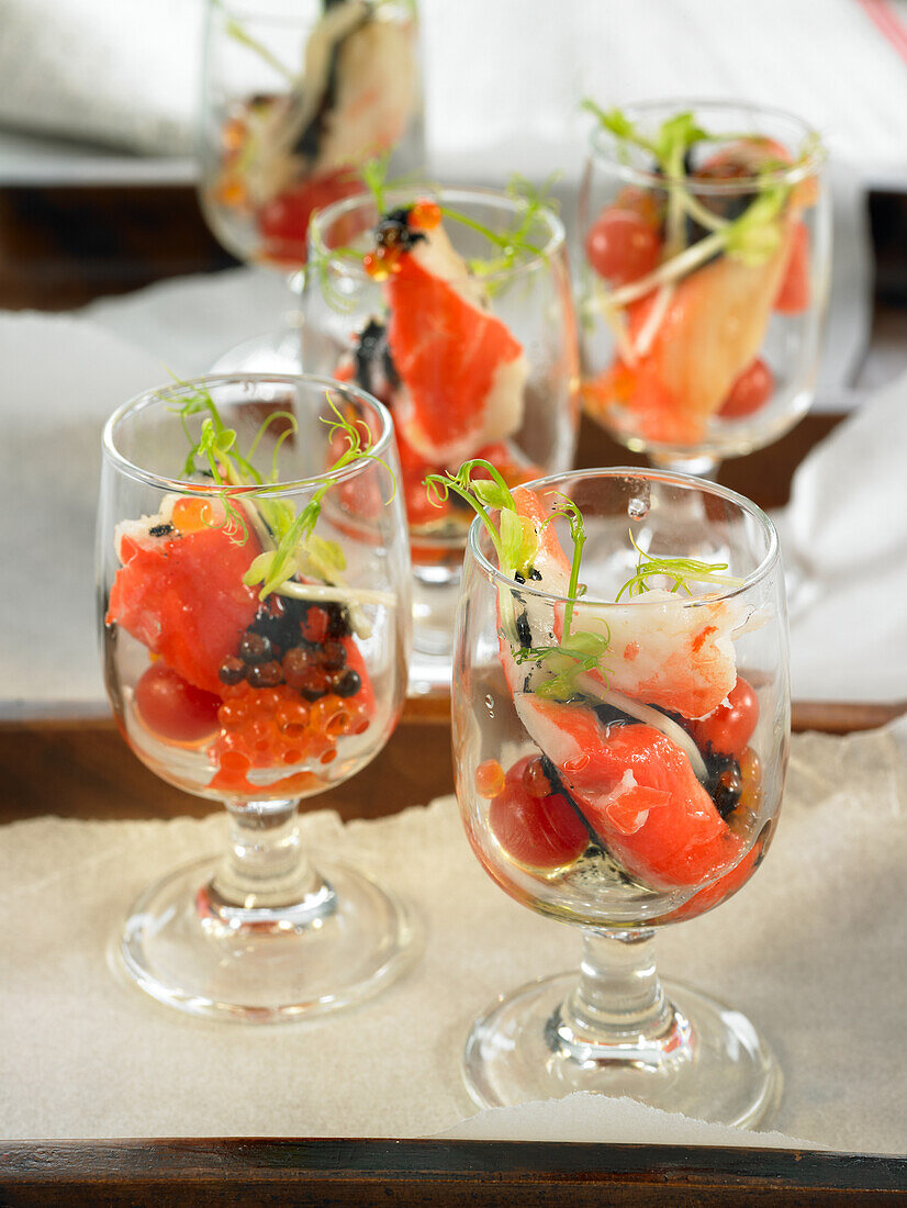 Verrine aperitifs with dried meat, trout caviar, crab noodles, asparagus shoots and vinaigrette