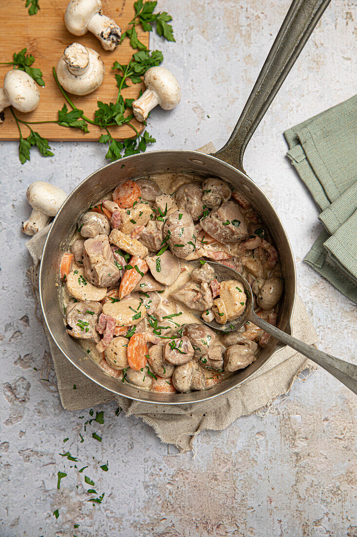 Veal kidney fricassee with mushrooms, veal dumplings, carrots, bacon, and parsley in cream sauce