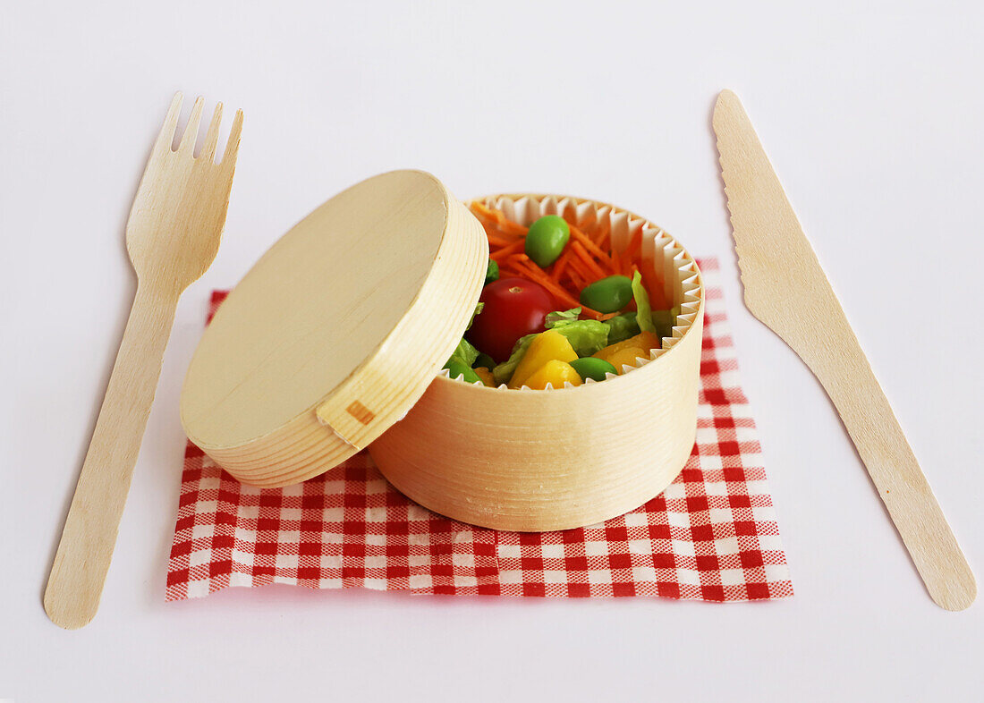 Lunch box with mixed salad and wooden cutlery