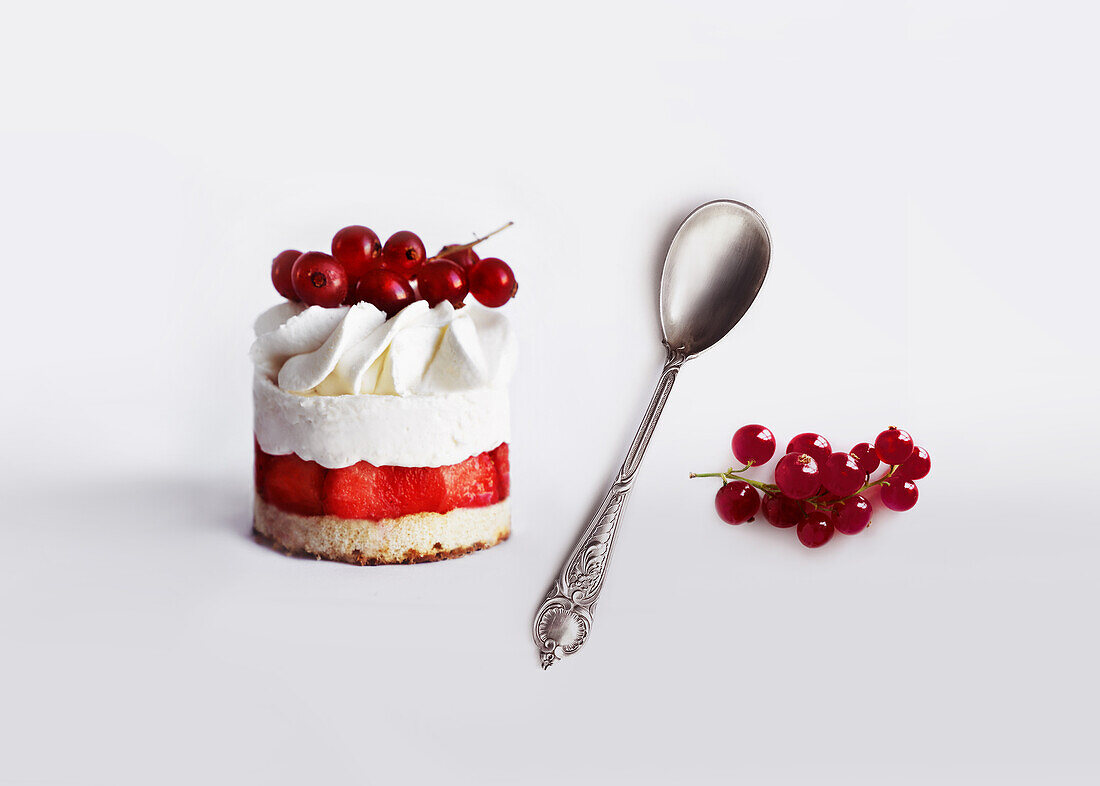 Strawberry cream tart with currants against a white background