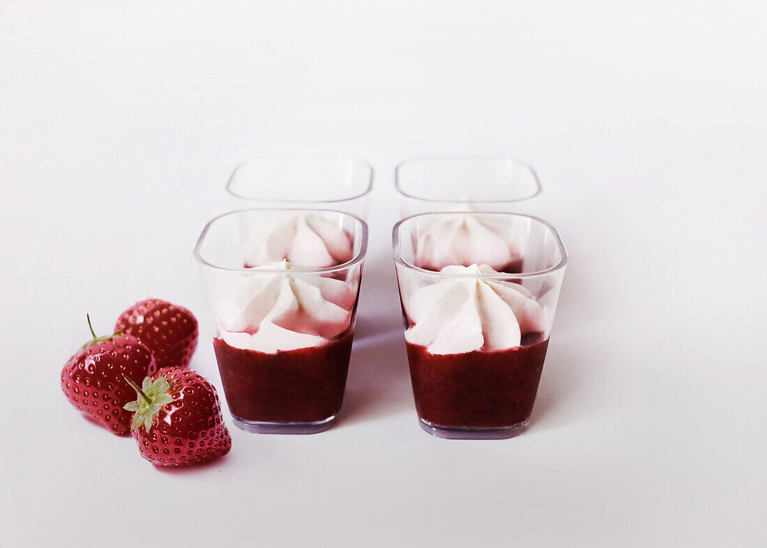 Strawberry puree with whipped cream on top in glasses