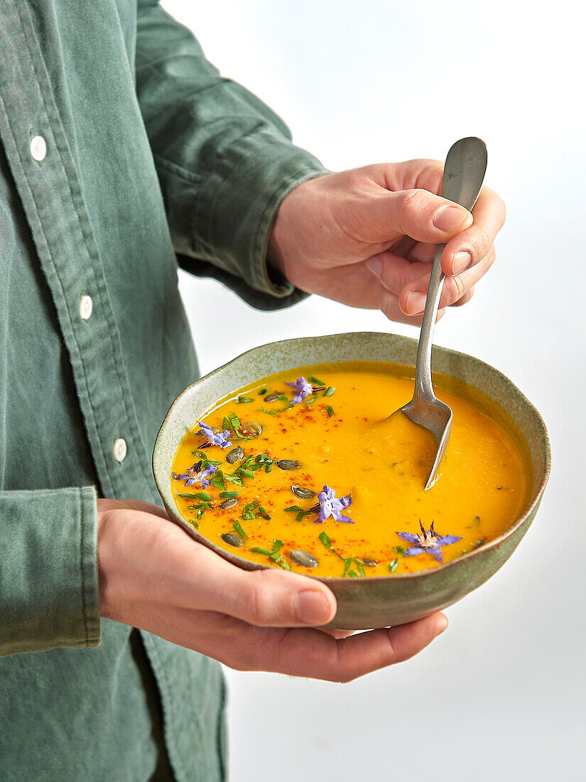 Sweet pumpkin soup with pears and edible flowers