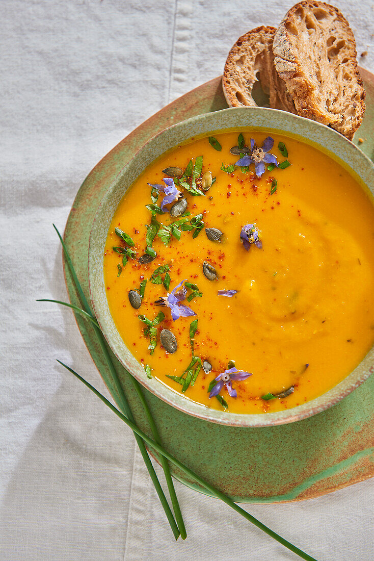 Cream of pumpkin soup with edible flowers