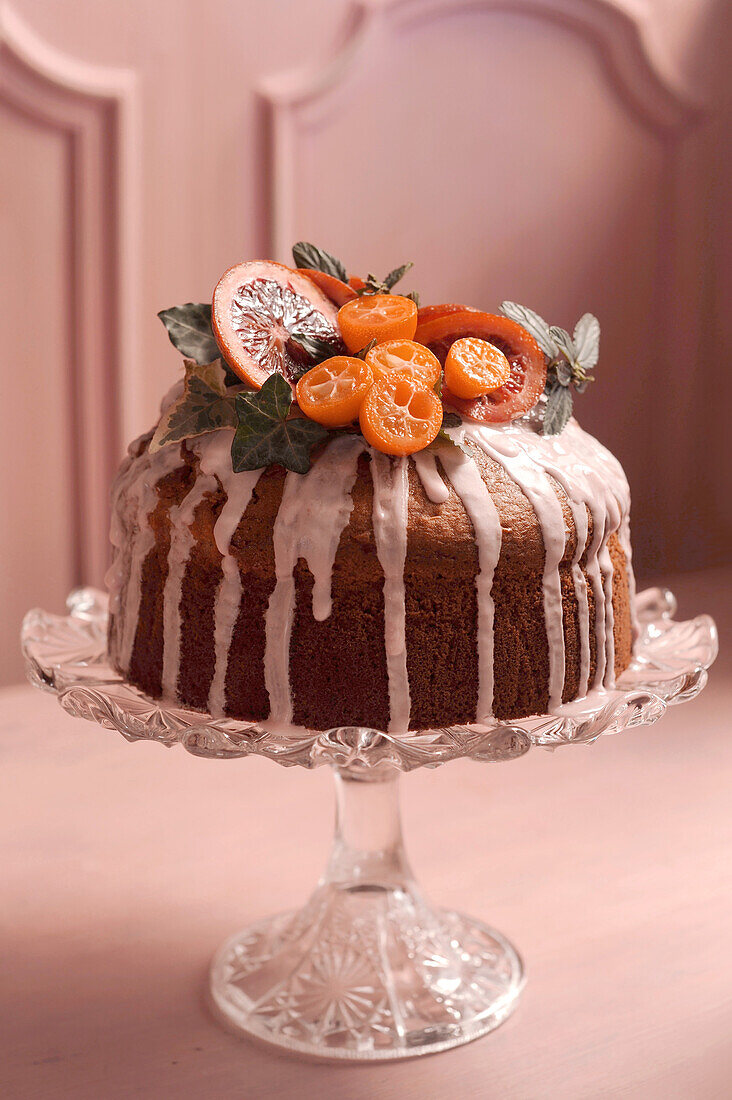 Blutorangenkuchen mit Zuckerglasur und Früchten dekoriert