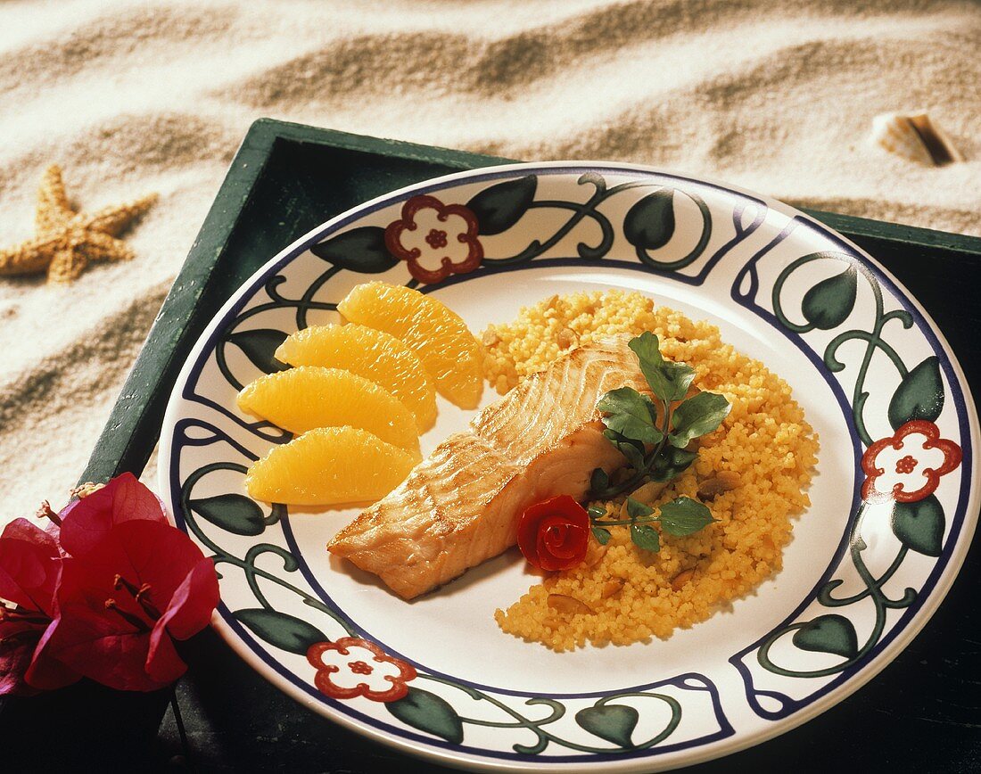 Lachsfilet mit Couscous und Orangenfilets auf Teller