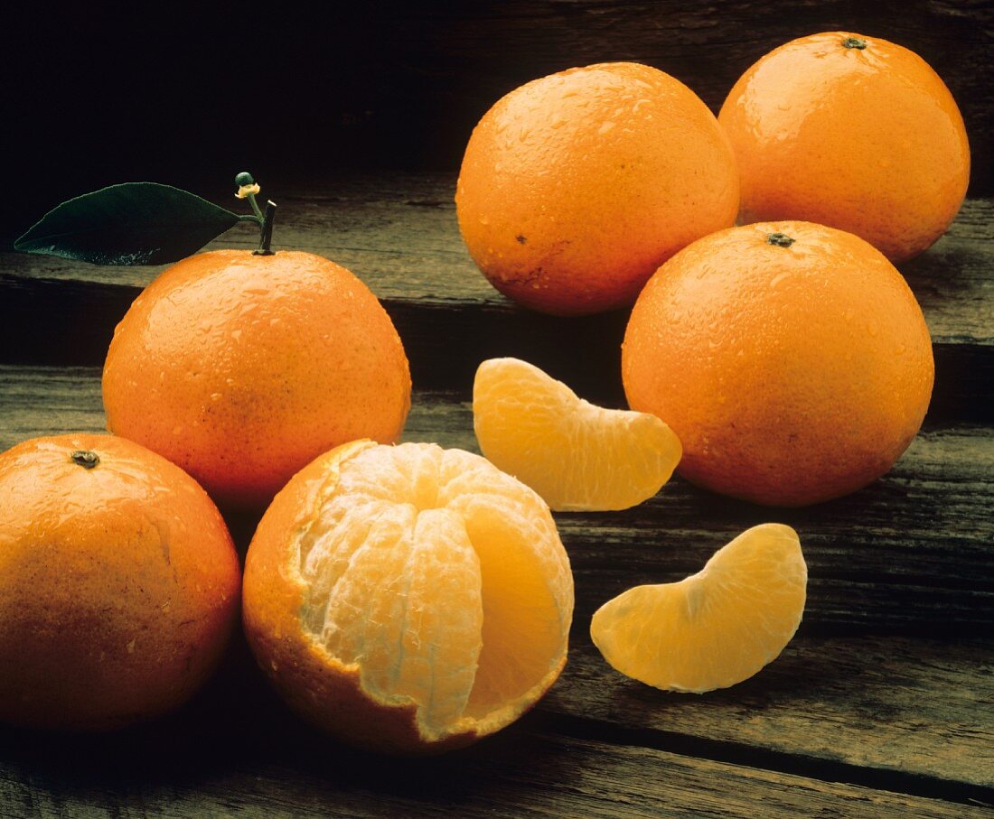 Tangerinen mit Wassertropfen, ganz & halb geschält
