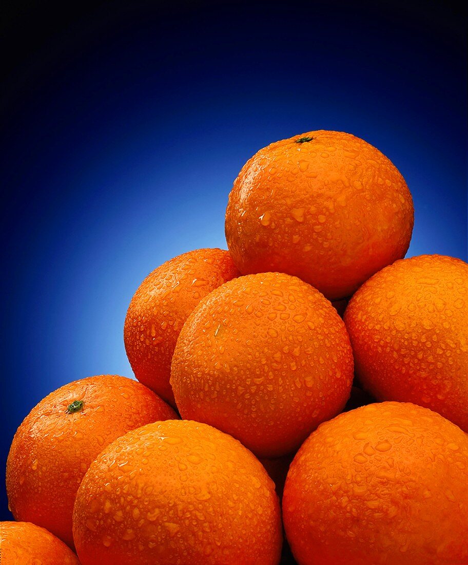 Ein Haufen Orangen mit Wassertropfen