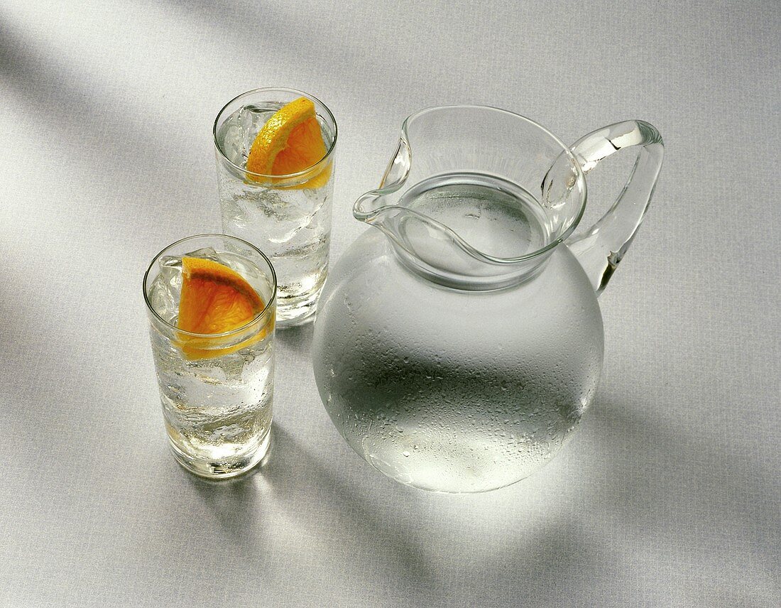 Wasserkrug & zwei Gläser Wasser mit Eiswürfeln & Grapefruit