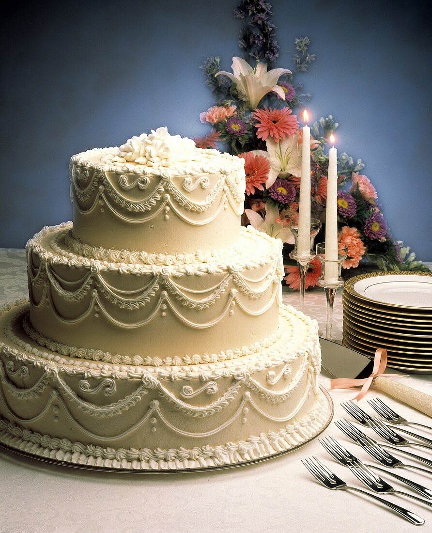 Dreistöckige weiße Hochzeitstorte mit Zuckergussverzierungen