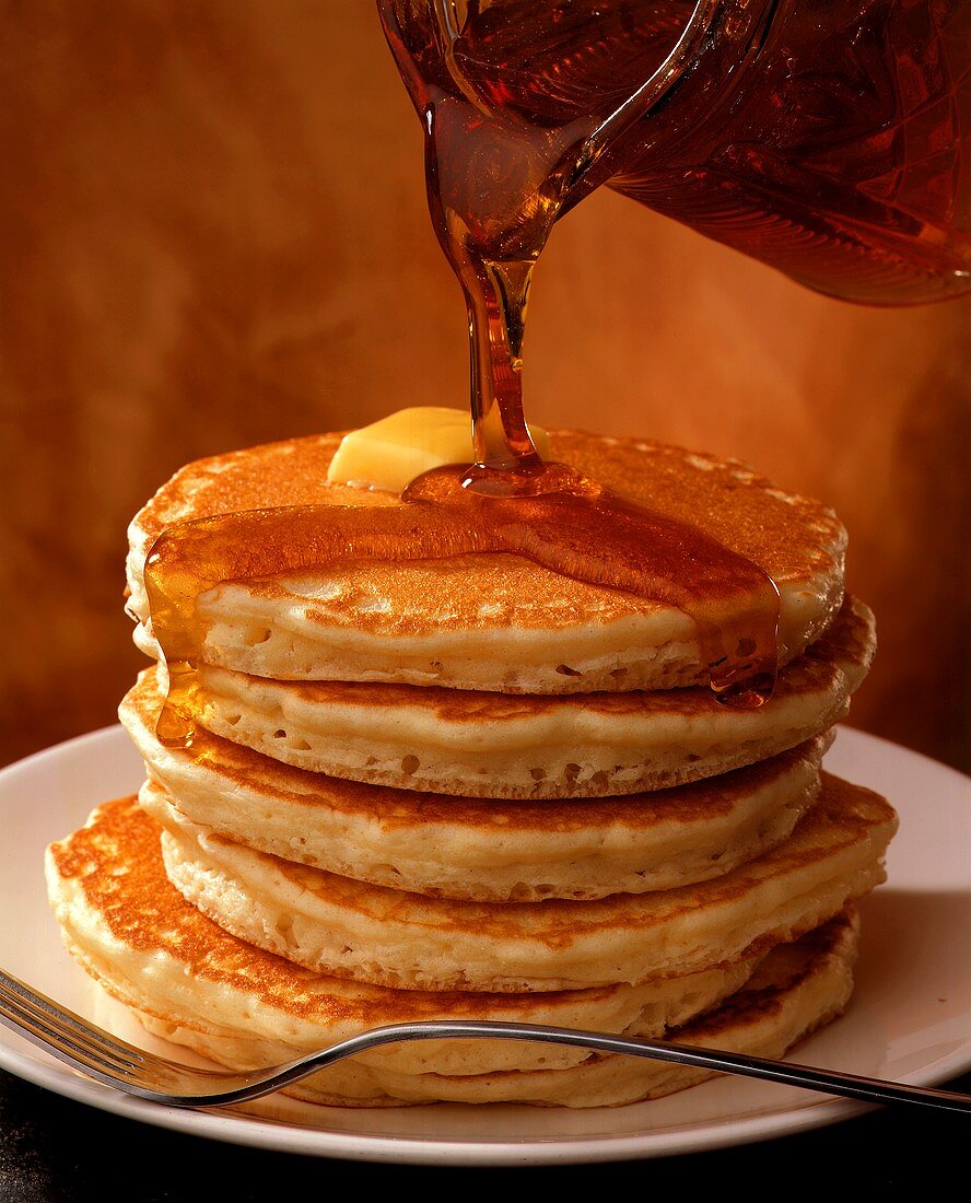 Geschichtete Pancakes (Pfannkuchen), mit Ahornsirup begossen