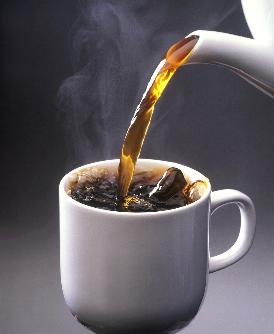Heisser Kaffee wird in weiße Tasse gegossen