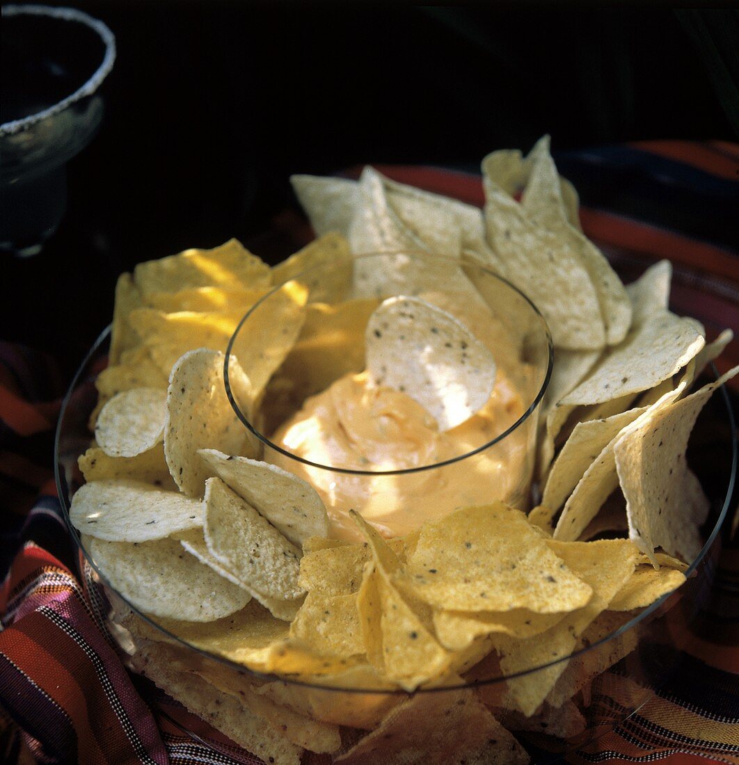 Verschiedene Maischips mit würzigem Käsedip in Glasschale