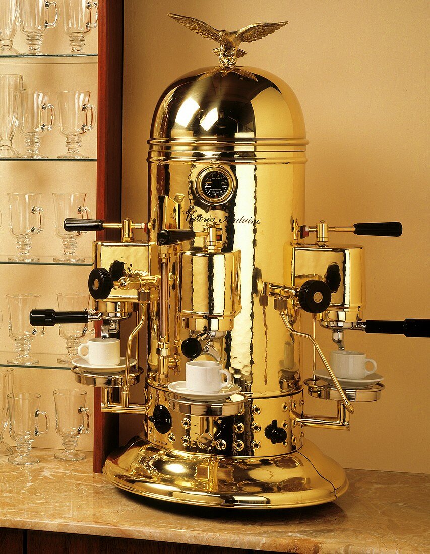 Espressomaschine aus Messing mit drei Espressotassen