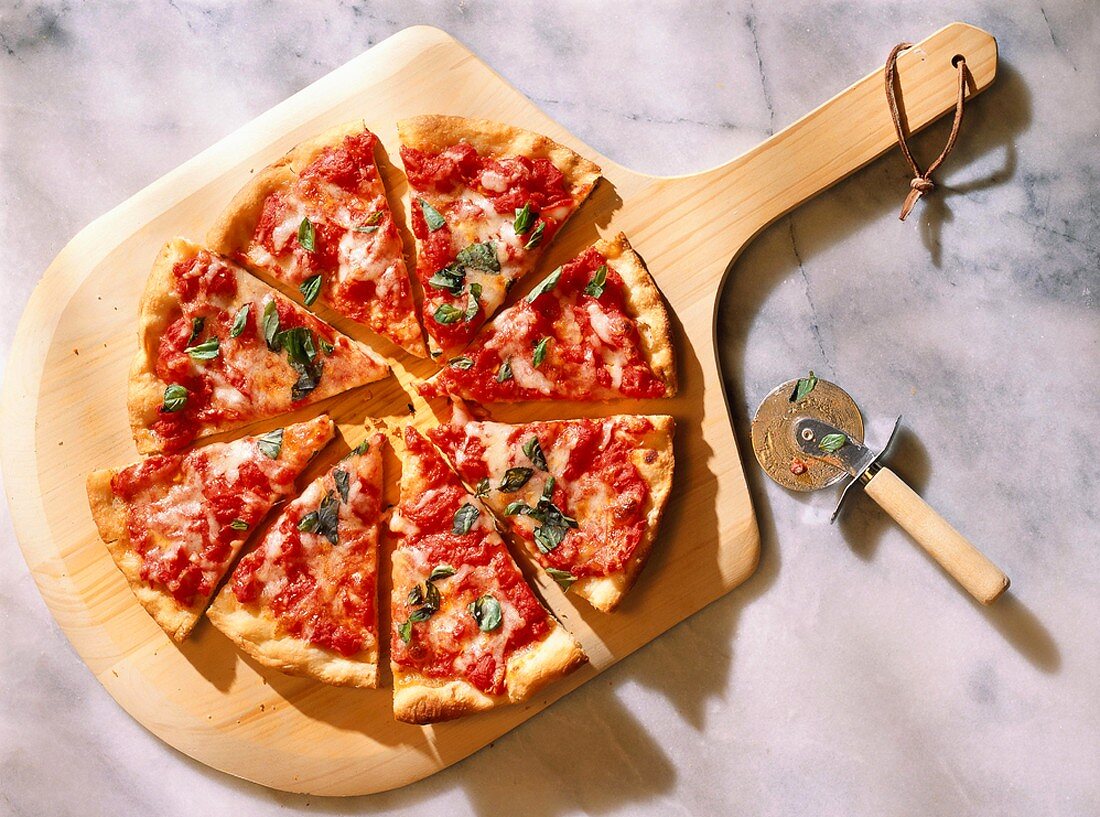 Pizza Margherita mit Tomaten,Käse,Basilikum auf Schneidebrett