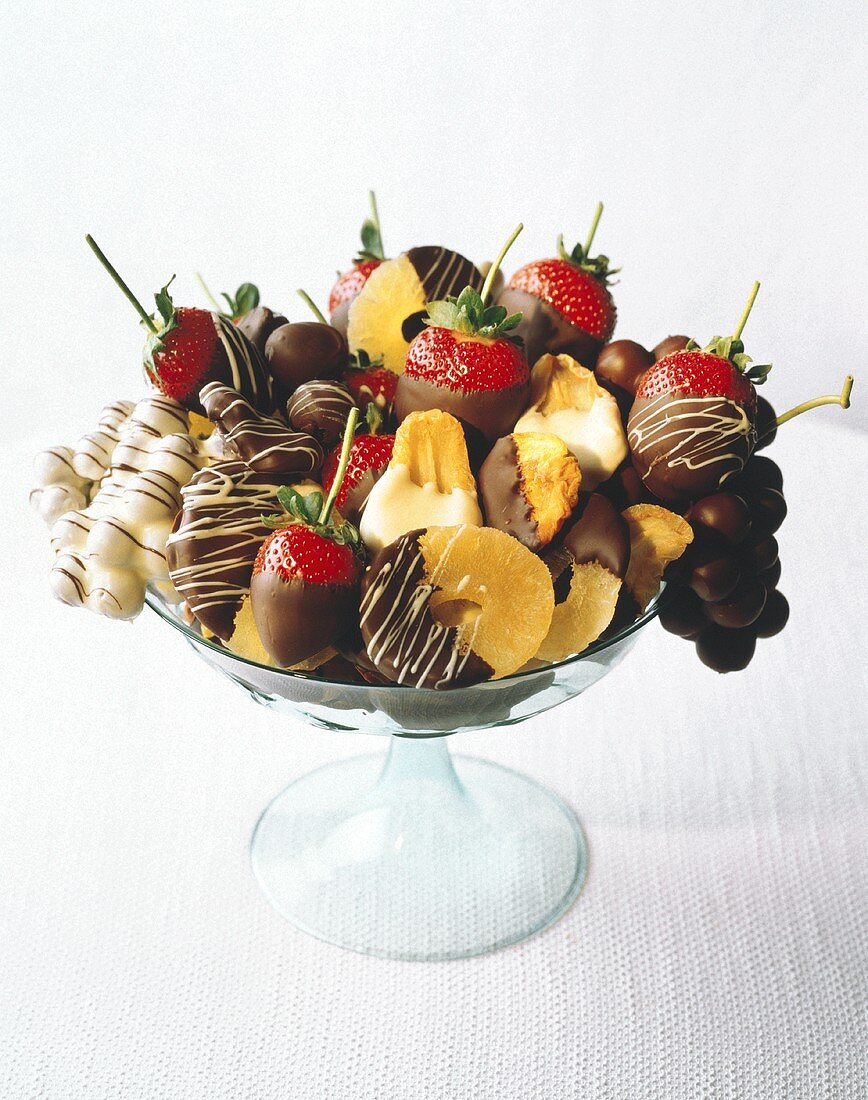 Verschiedene Früchte, in Schokolade getaucht, in Glasschale