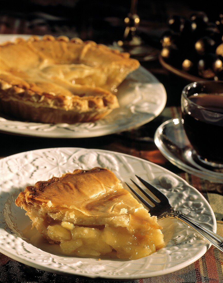 Ein Stück Applepie auf Teller, vor ganzer Applepie