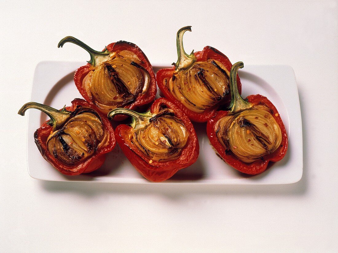 Rote Paprika, halbiert, gefüllt mit gebratenen Zwiebeln