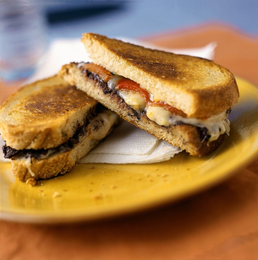 Überbackenes Sandwich mit Käse & Tomaten auf Teller