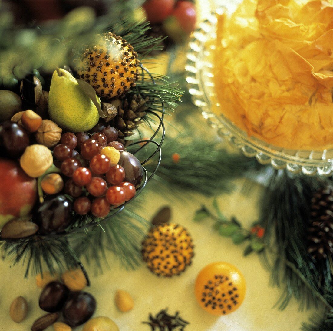 Fruit bowl decorated for Christmas and a pie on table