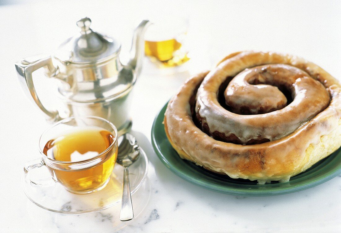 Hefeteigschnecke mit Zuckerglasur & Teetasse, Teekanne