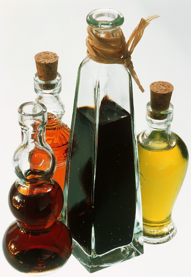 Drei Essigsorten in Flaschen und Olivenöl