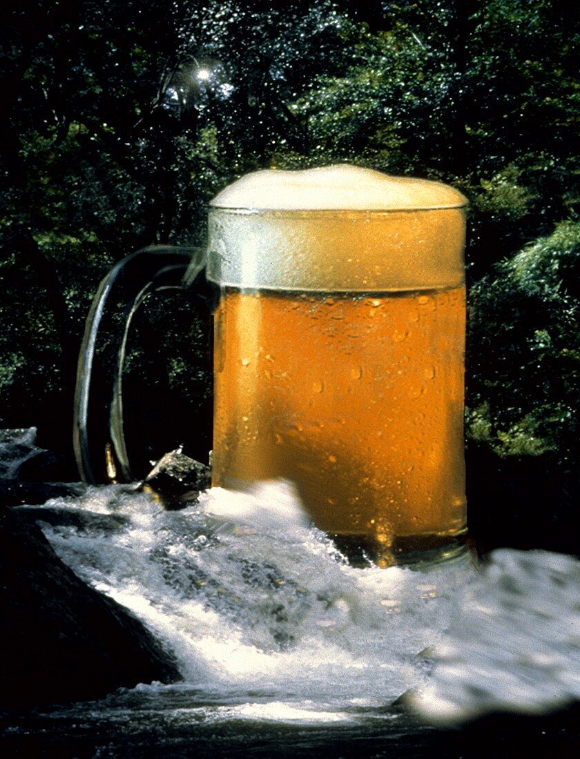 Ein voller Bierkrug in einem Wasserfall