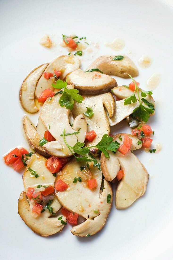 Fried porcini mushrooms with diced tomatoes and parsley