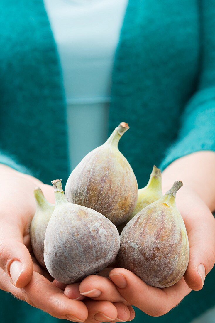 A woman holding fresh figs