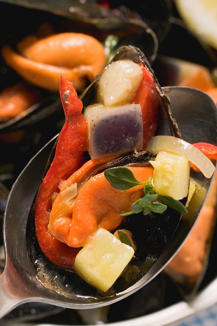 Mussels with vegetables on a spoon